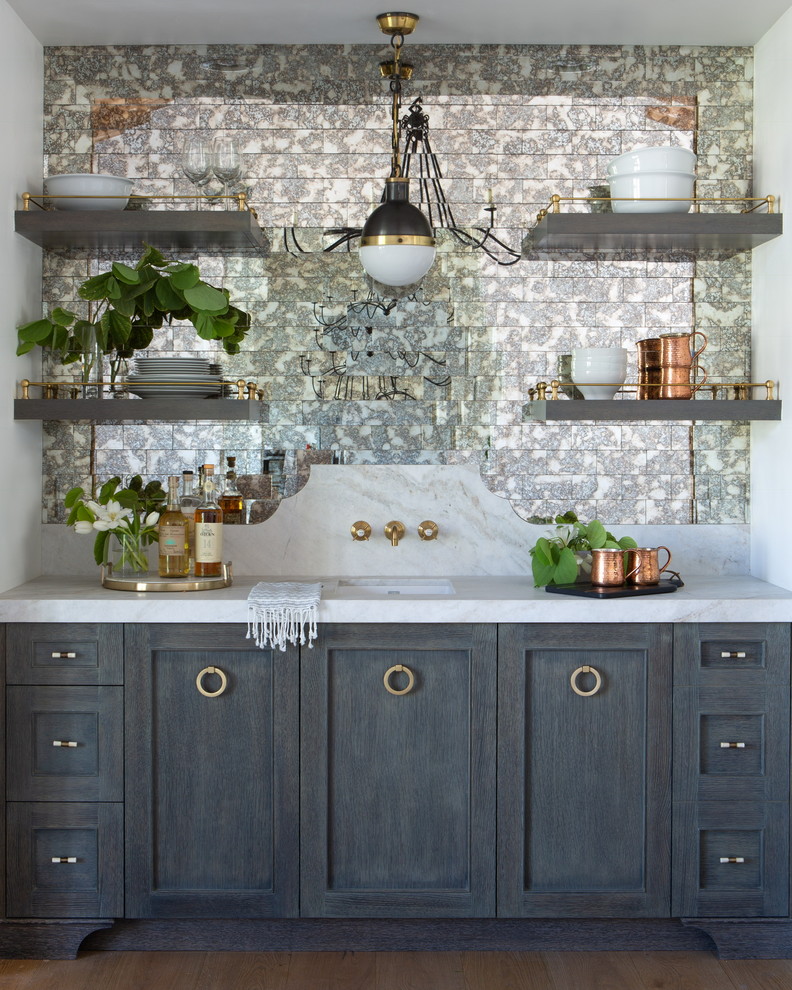 Inspiration for a mid-sized country single-wall wet bar in Phoenix with an undermount sink, shaker cabinets, grey cabinets, marble benchtops, multi-coloured splashback, mirror splashback, light hardwood floors and white benchtop.