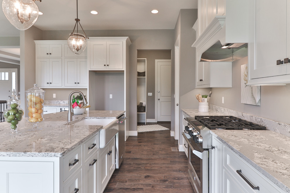 Mid-sized transitional l-shaped dark wood floor and brown floor open concept kitchen photo in St Louis with a farmhouse sink, shaker cabinets, white cabinets, granite countertops, gray backsplash, stainless steel appliances and an island
