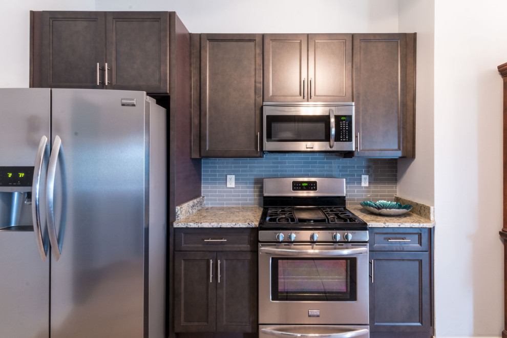 Inspiration for a small galley cement tile floor and beige floor eat-in kitchen remodel with an undermount sink, flat-panel cabinets, gray cabinets, granite countertops, gray backsplash, glass tile backsplash, stainless steel appliances, no island and white countertops