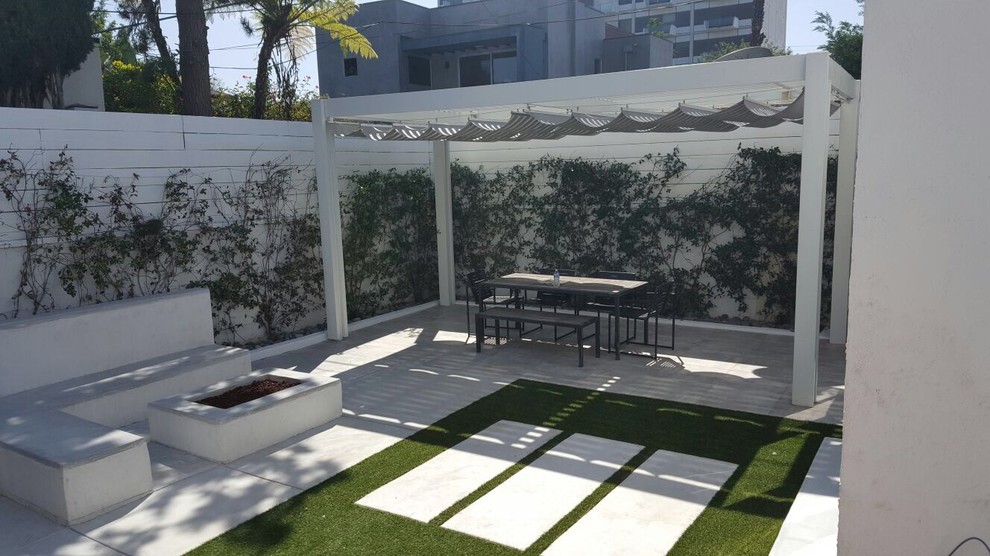 Photo of a small modern backyard patio in Los Angeles with a fire feature, concrete slab and a gazebo/cabana.