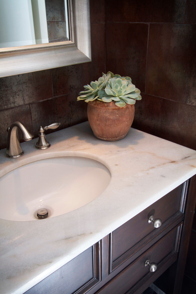 Example of a small transitional brown tile and porcelain tile marble floor bathroom design in Phoenix with dark wood cabinets, quartzite countertops and brown walls