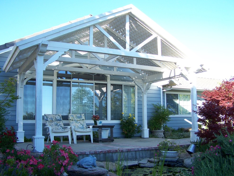 Inspiration for a large traditional backyard patio in Other with concrete slab and a pergola.