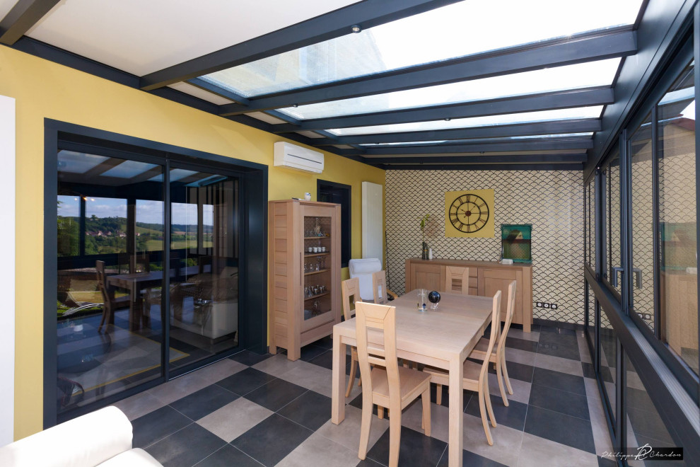 Esempio di una sala da pranzo aperta verso il soggiorno industriale di medie dimensioni con pareti beige, pavimento con piastrelle in ceramica, pavimento nero e carta da parati
