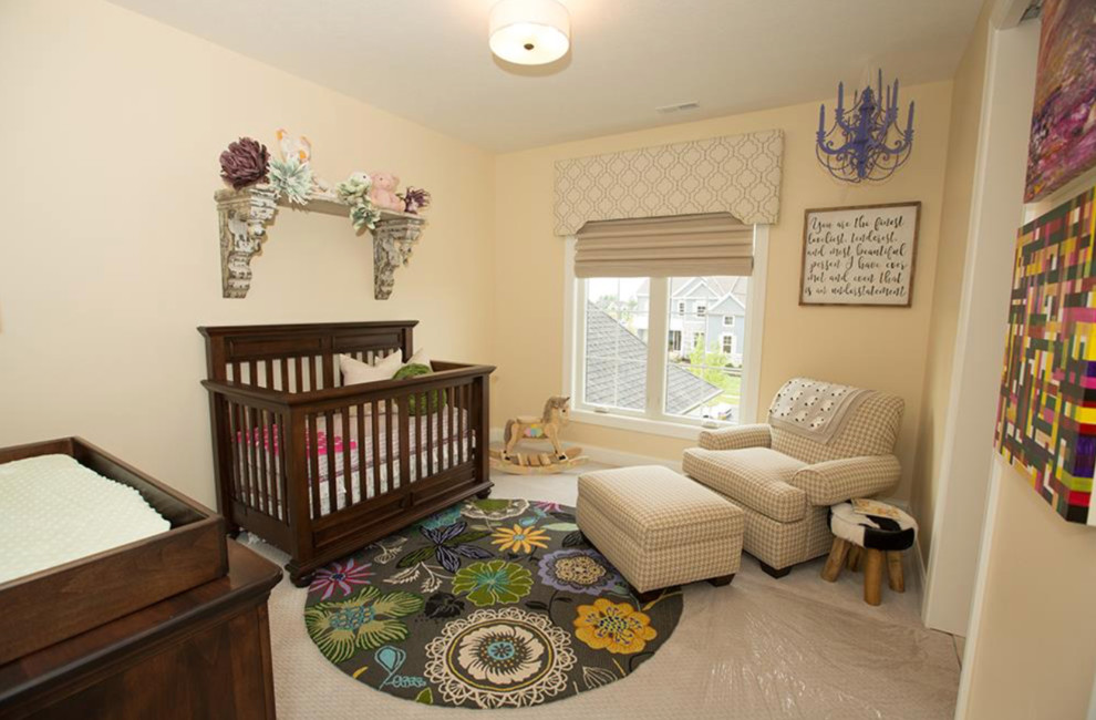 Design ideas for a mid-sized transitional nursery for girls in Columbus with beige walls and carpet.