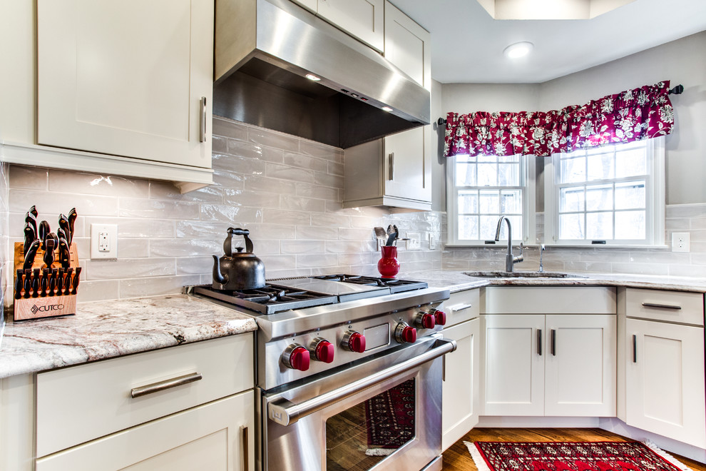 This is an example of a mid-sized traditional kitchen in DC Metro with an undermount sink, granite benchtops, stainless steel appliances, medium hardwood floors, with island, shaker cabinets, white cabinets and grey splashback.