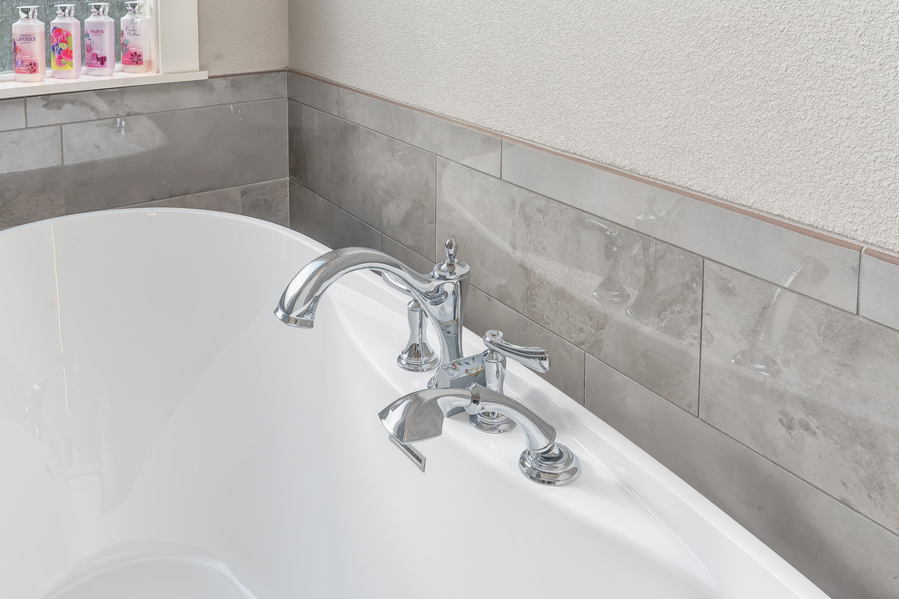 Transitional master gray tile and porcelain tile porcelain tile and gray floor freestanding bathtub photo in Boise with shaker cabinets, white cabinets, a two-piece toilet, gray walls, an undermount sink, quartz countertops and a hinged shower door