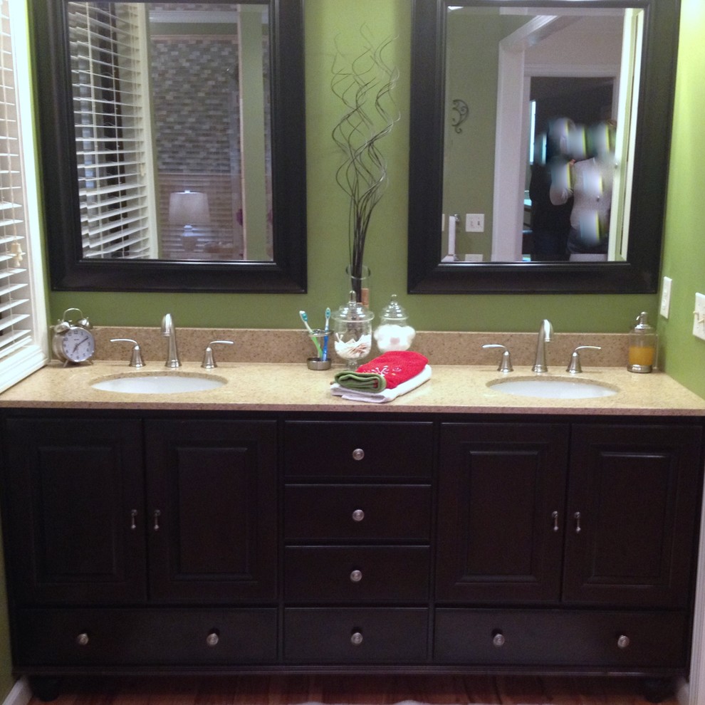 This is an example of a mid-sized transitional master bathroom in Nashville with raised-panel cabinets, brown cabinets, green walls, medium hardwood floors, an undermount sink, granite benchtops and brown floor.