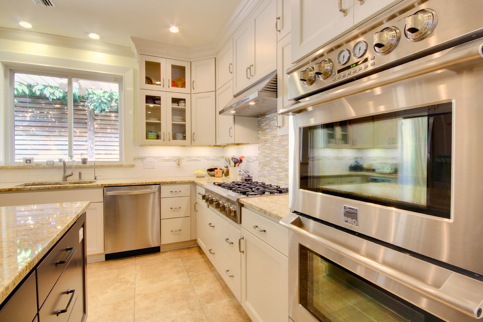 Example of a transitional u-shaped eat-in kitchen design in Miami with an undermount sink, recessed-panel cabinets, white cabinets, granite countertops, multicolored backsplash and stainless steel appliances