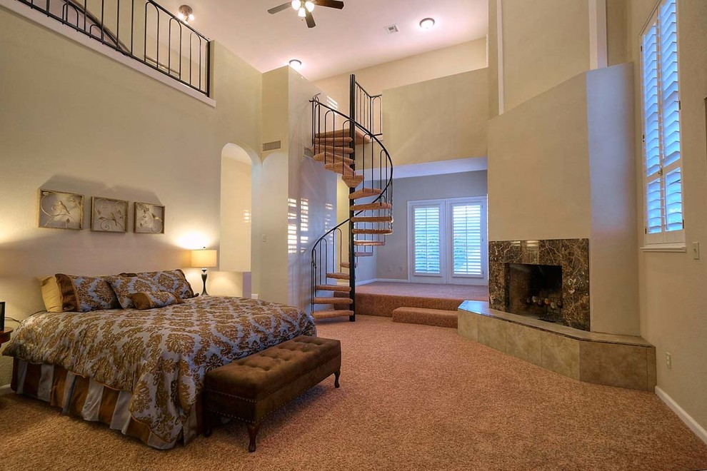 Photo of a mediterranean master bedroom in Phoenix with beige walls, carpet, a corner fireplace and a stone fireplace surround.
