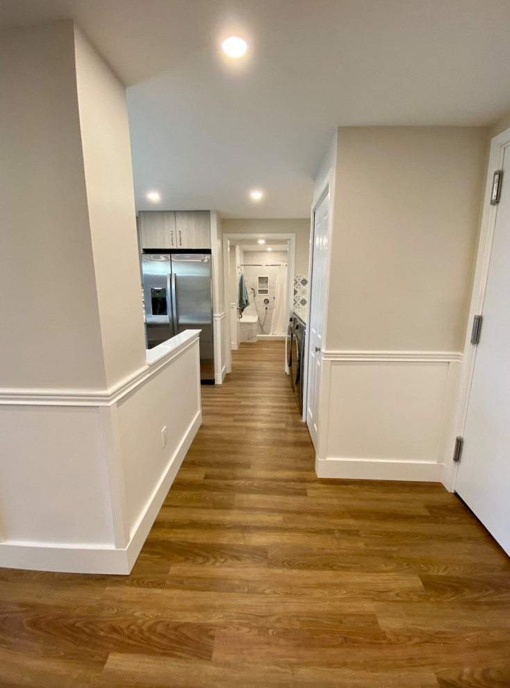 Photo of a mid-sized transitional hallway in Philadelphia with grey walls, vinyl floors, brown floor and decorative wall panelling.