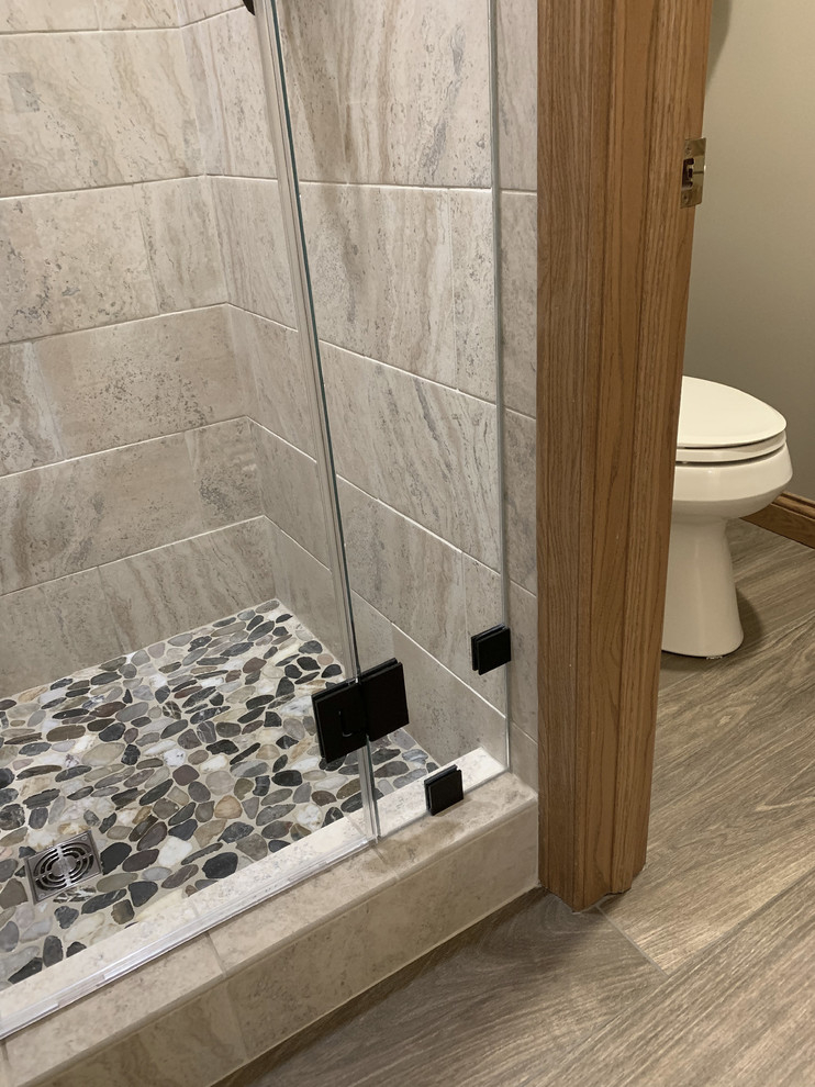 Example of a large transitional master beige tile and ceramic tile linoleum floor and brown floor home design design with recessed-panel cabinets, white cabinets, a two-piece toilet, beige walls, an undermount sink, granite countertops, a hinged shower door and multicolored countertops