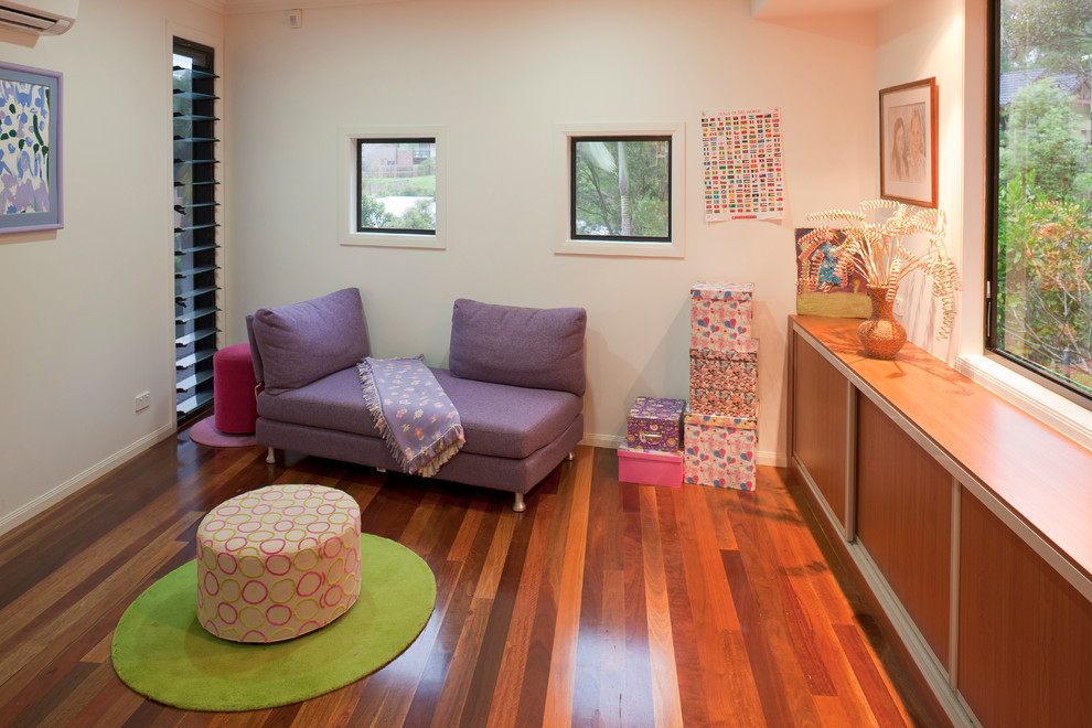 Photo of a small contemporary kids' playroom for kids 4-10 years old and girls in Brisbane with medium hardwood floors and white walls.