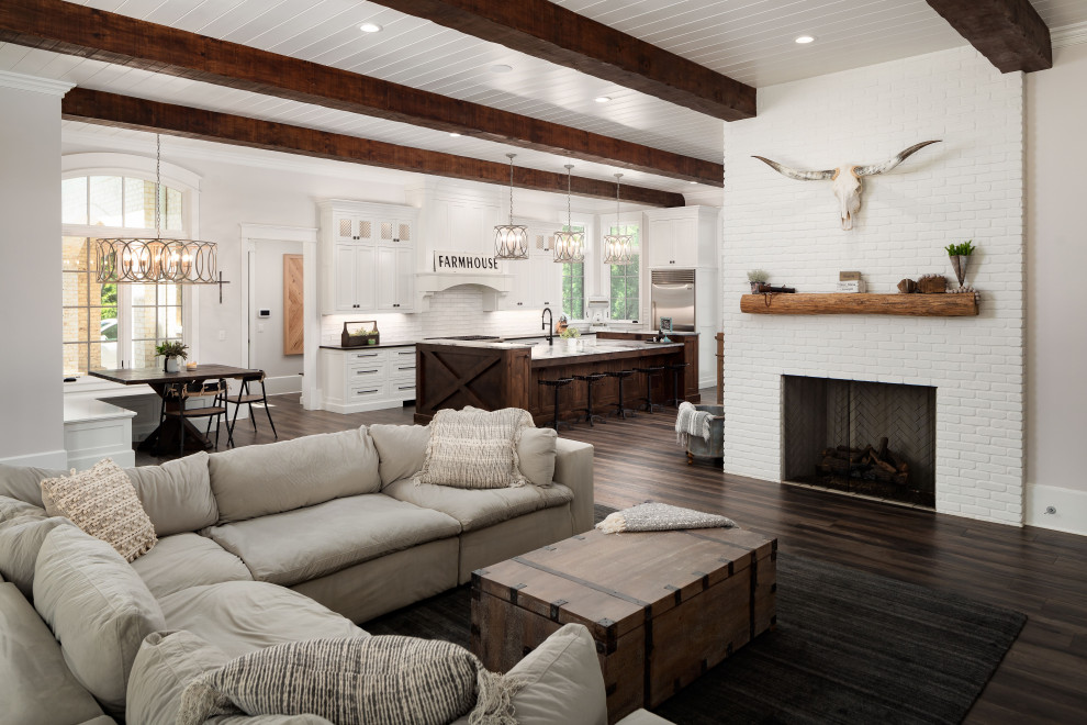 Design ideas for a country open concept living room in Atlanta with grey walls, dark hardwood floors, a standard fireplace, a brick fireplace surround, brown floor, exposed beam and timber.