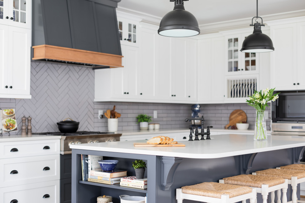Traditional kitchen in Other with a belfast sink, shaker cabinets, white cabinets, engineered stone countertops, grey splashback, metro tiled splashback, stainless steel appliances, medium hardwood flooring, brown floors and white worktops.