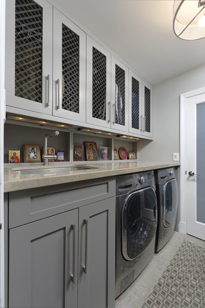 Inspiration for a mid-sized transitional galley utility room in DC Metro with an undermount sink, shaker cabinets, grey cabinets, limestone benchtops, grey walls, marble floors, a side-by-side washer and dryer, grey floor and grey benchtop.