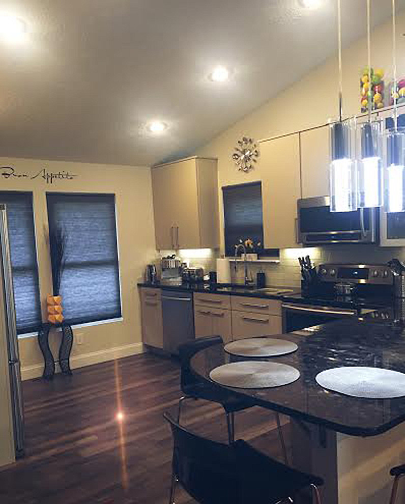 Kitchen - mid-sized modern porcelain tile kitchen idea in Baltimore with a single-bowl sink, flat-panel cabinets, beige cabinets, granite countertops, beige backsplash, glass tile backsplash and stainless steel appliances