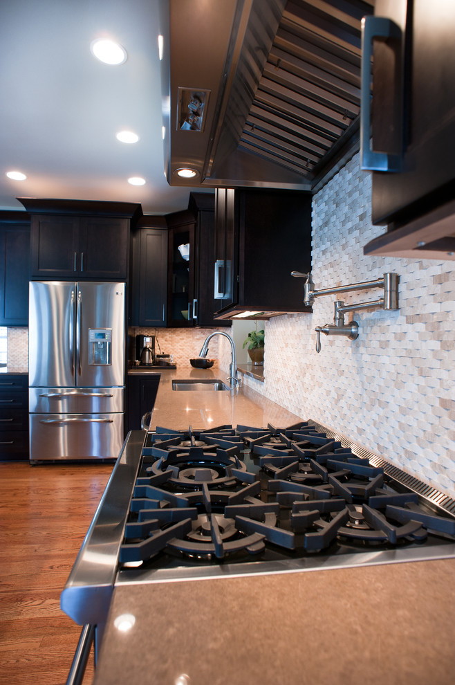 Kitchen - mid-sized transitional l-shaped kitchen idea in Charlotte with dark wood cabinets, granite countertops, white backsplash and an island