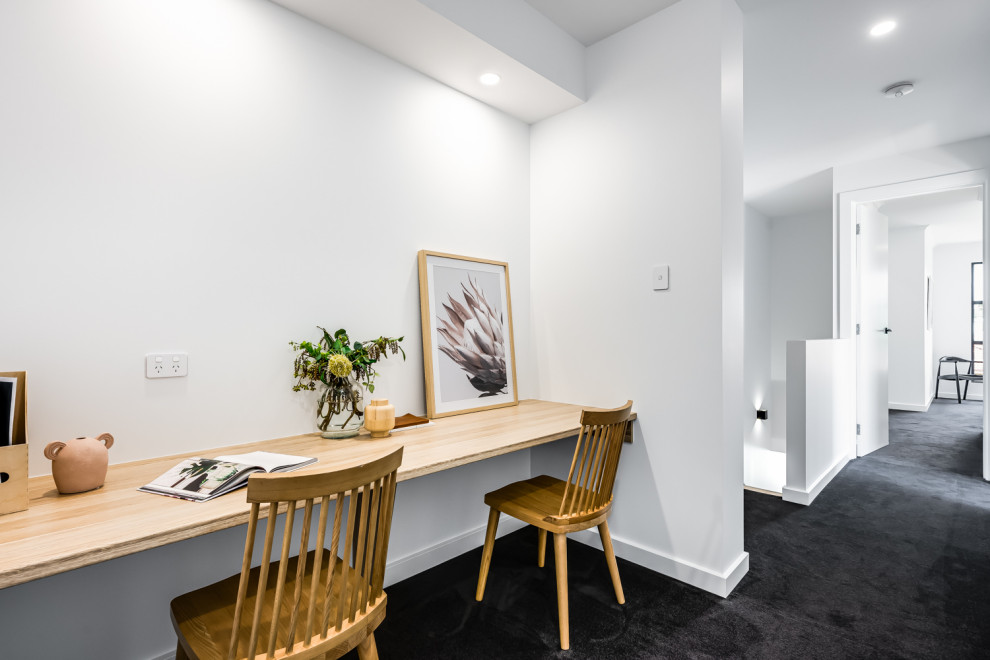 Imagen de despacho actual pequeño con paredes blancas, moqueta, escritorio independiente y suelo gris