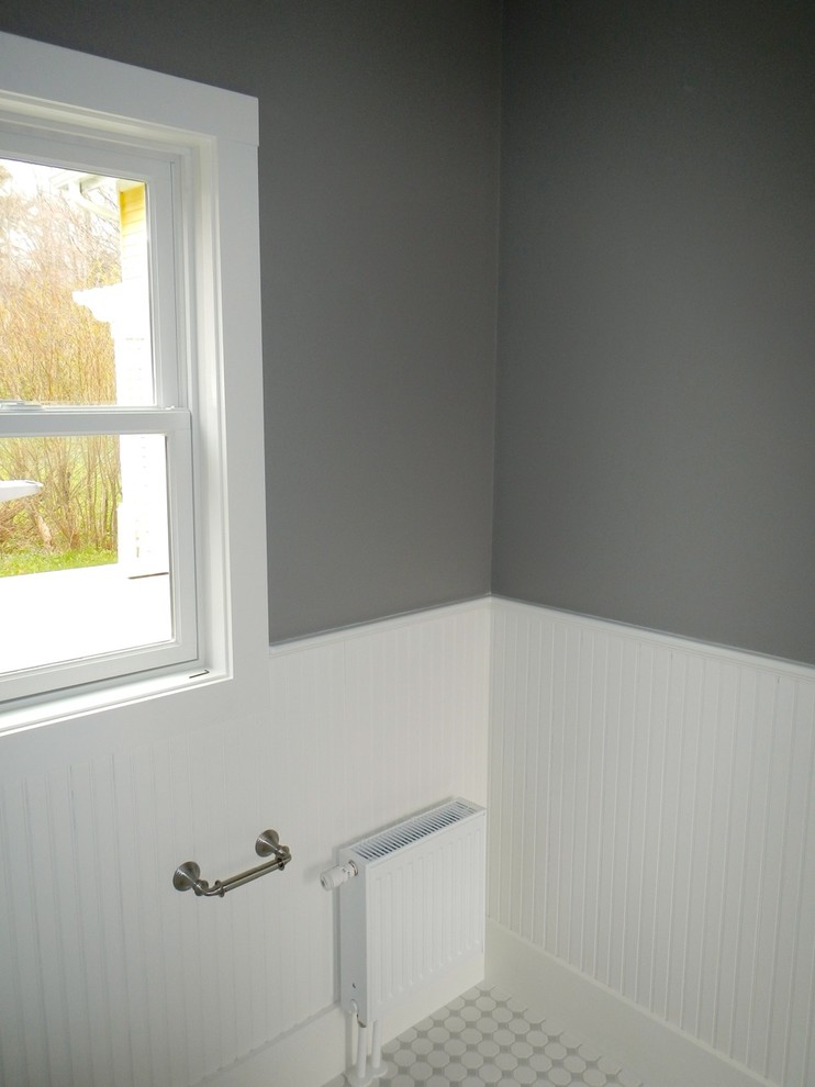 This is an example of a mid-sized beach style 3/4 bathroom in Portland Maine with a pedestal sink, a corner shower, a two-piece toilet, white tile, ceramic tile, grey walls and ceramic floors.