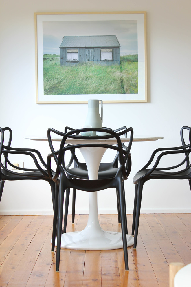 This is an example of a small scandinavian separate dining room in Sydney with white walls.