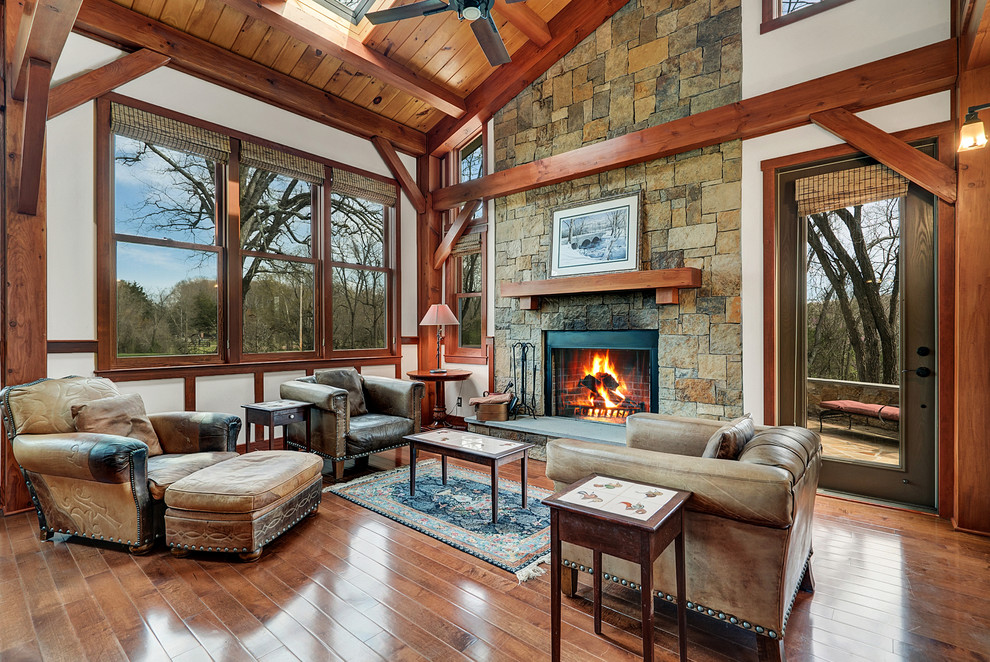 Photo of a mid-sized country formal open concept living room in DC Metro with a stone fireplace surround, brown floor, white walls, dark hardwood floors and a standard fireplace.