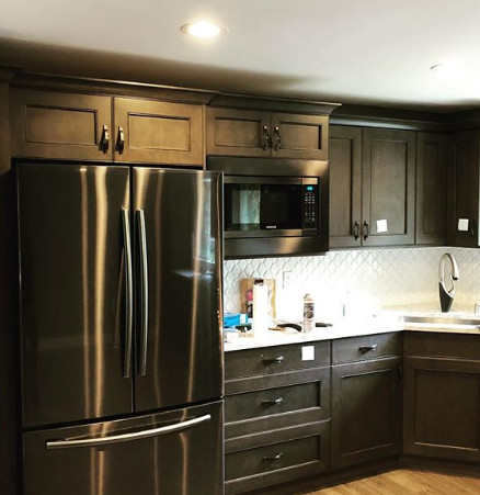 Kitchen - mid-sized transitional light wood floor and brown floor kitchen idea in Seattle with an undermount sink, flat-panel cabinets, brown cabinets, quartz countertops, white backsplash, mosaic tile backsplash, stainless steel appliances and white countertops
