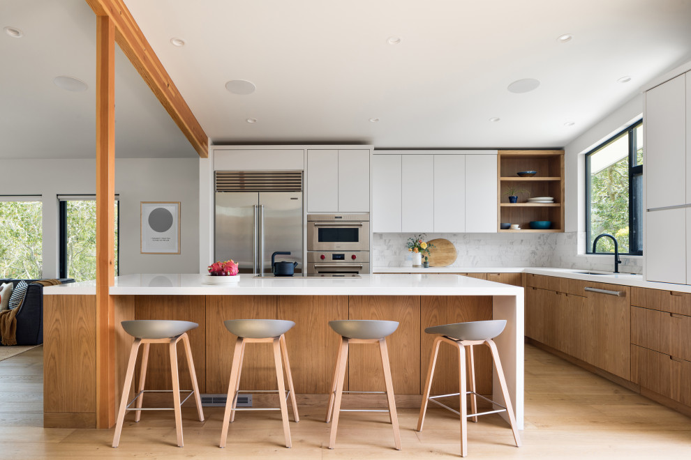 Offene Retro Küche in L-Form mit flächenbündigen Schrankfronten, Küchengeräten aus Edelstahl, hellem Holzboden, Kücheninsel, weißer Arbeitsplatte und gewölbter Decke in San Francisco