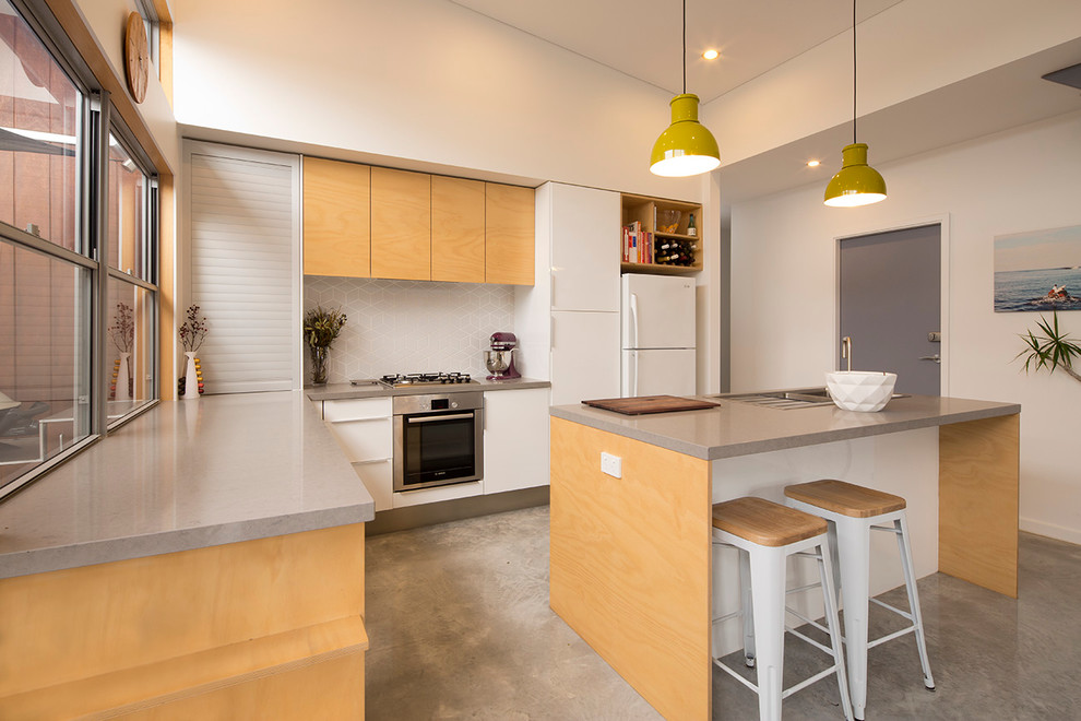 Inspiration for a small modern l-shaped eat-in kitchen in Perth with light wood cabinets, quartz benchtops, grey splashback, ceramic splashback, stainless steel appliances, concrete floors and with island.