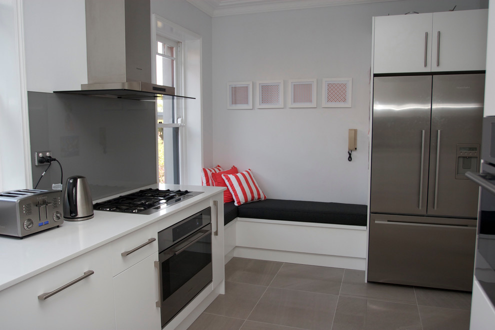 Design ideas for a modern kitchen in Sydney with grey splashback, glass sheet splashback, stainless steel appliances and grey floor.