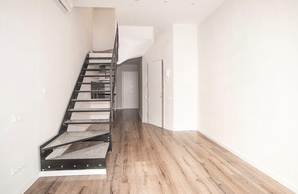 Ejemplo de salón abierto actual de tamaño medio sin chimenea con paredes blancas y suelo de madera en tonos medios