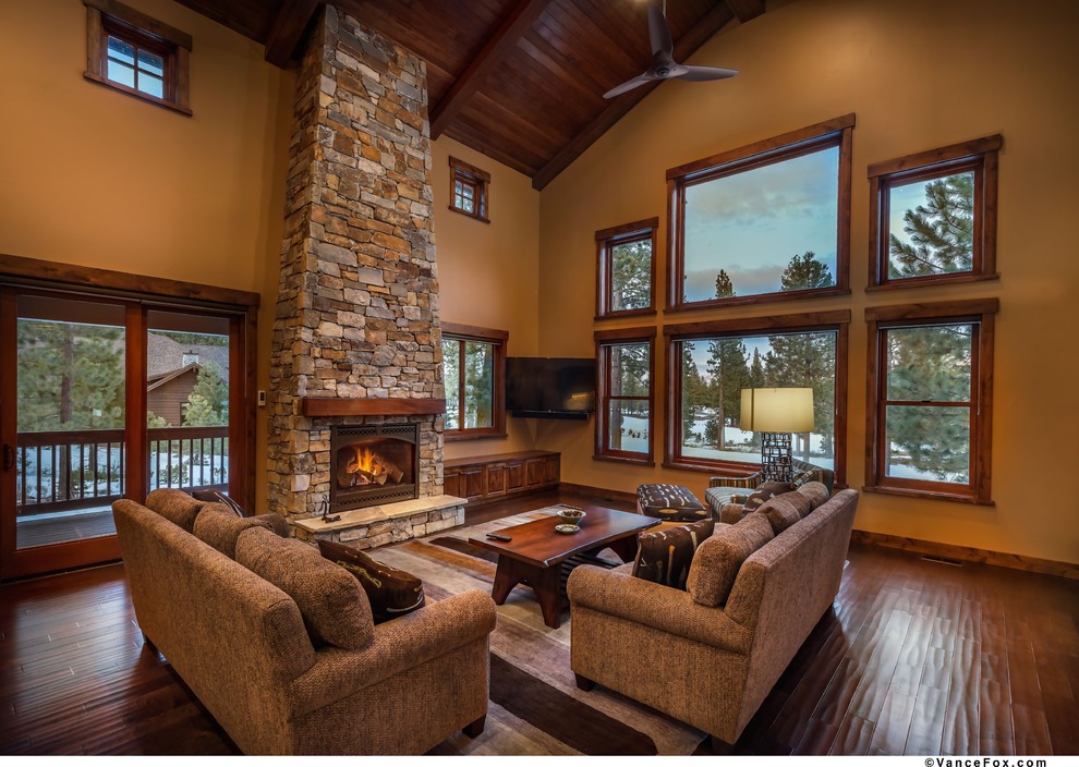 Expansive country open concept family room in Sacramento with brown walls, dark hardwood floors, a standard fireplace, a stone fireplace surround and a corner tv.