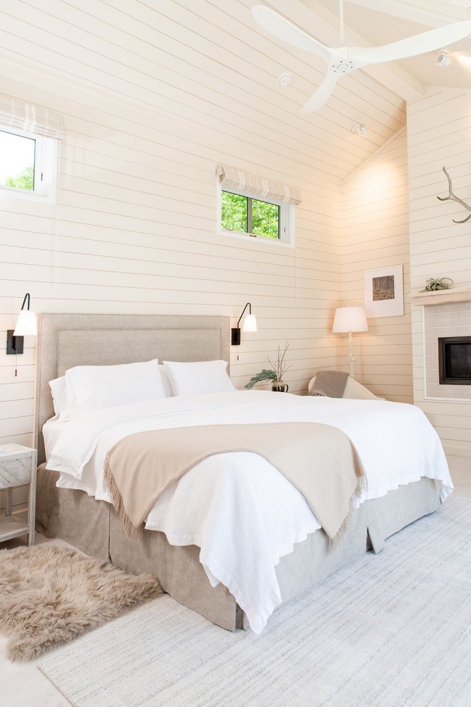 Großes Maritimes Hauptschlafzimmer mit beiger Wandfarbe, hellem Holzboden, Kamin, Kaminumrandung aus Holzdielen, weißem Boden, Holzdielendecke und Holzdielenwänden in Burlington