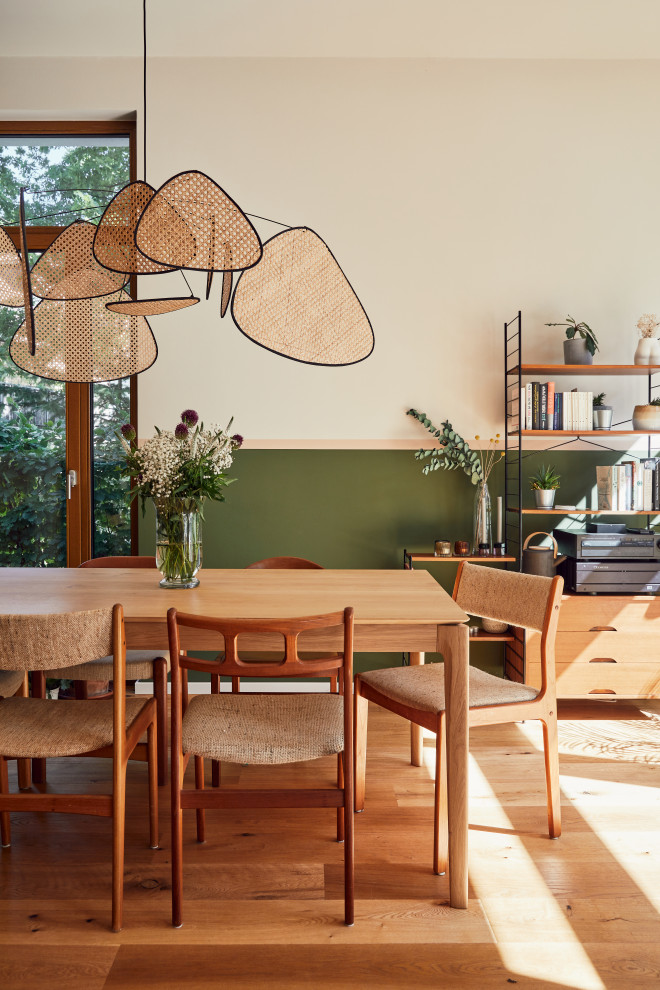 Bild på en mellanstor funkis matplats med öppen planlösning, med gröna väggar och målat trägolv