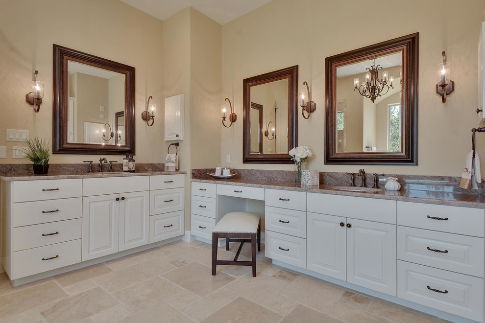 Photo of a large traditional master bathroom in Austin with white cabinets, a freestanding tub, a double shower, a one-piece toilet, beige tile, stone tile, beige walls, travertine floors, an undermount sink, granite benchtops and raised-panel cabinets.