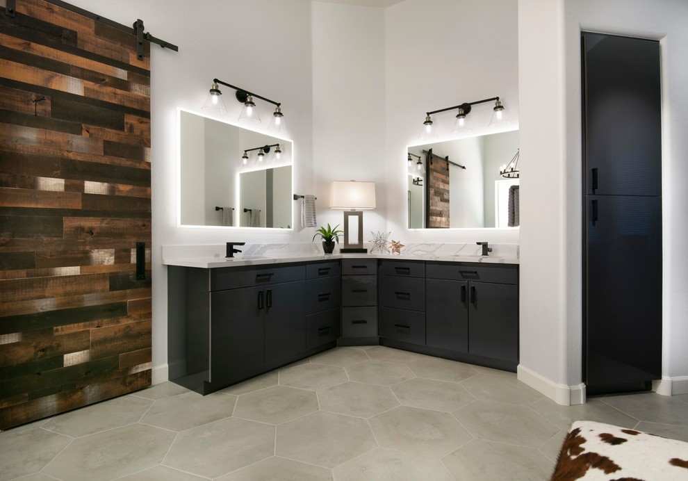 Design ideas for an industrial master bathroom in Phoenix with flat-panel cabinets, grey cabinets, a freestanding tub, a corner shower, white tile, porcelain tile, grey walls, cement tiles, an undermount sink, engineered quartz benchtops, grey floor, a hinged shower door and white benchtops.
