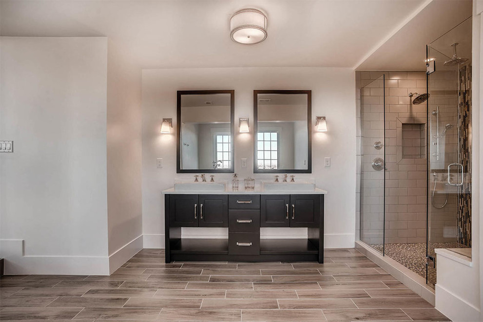 Photo of a large contemporary master bathroom in Denver with black cabinets, a claw-foot tub, a double shower, gray tile, porcelain tile, white walls, porcelain floors, engineered quartz benchtops, brown floor, a hinged shower door and beige benchtops.