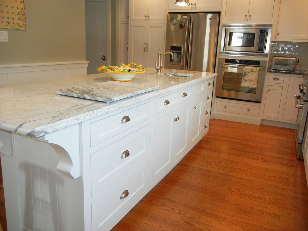 Inspiration for a large transitional u-shaped medium tone wood floor open concept kitchen remodel with an undermount sink, shaker cabinets, white cabinets, subway tile backsplash, stainless steel appliances, an island, granite countertops and white backsplash