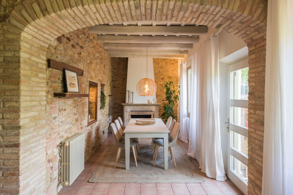 Diseño de comedor campestre de tamaño medio con todas las chimeneas, marco de chimenea de piedra, vigas vistas y todos los tratamientos de pared