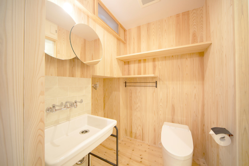 This is an example of a small scandinavian powder room in Tokyo Suburbs with open cabinets, white cabinets, a one-piece toilet, gray tile, porcelain tile, beige walls, light hardwood floors, beige floor, a freestanding vanity and decorative wall panelling.