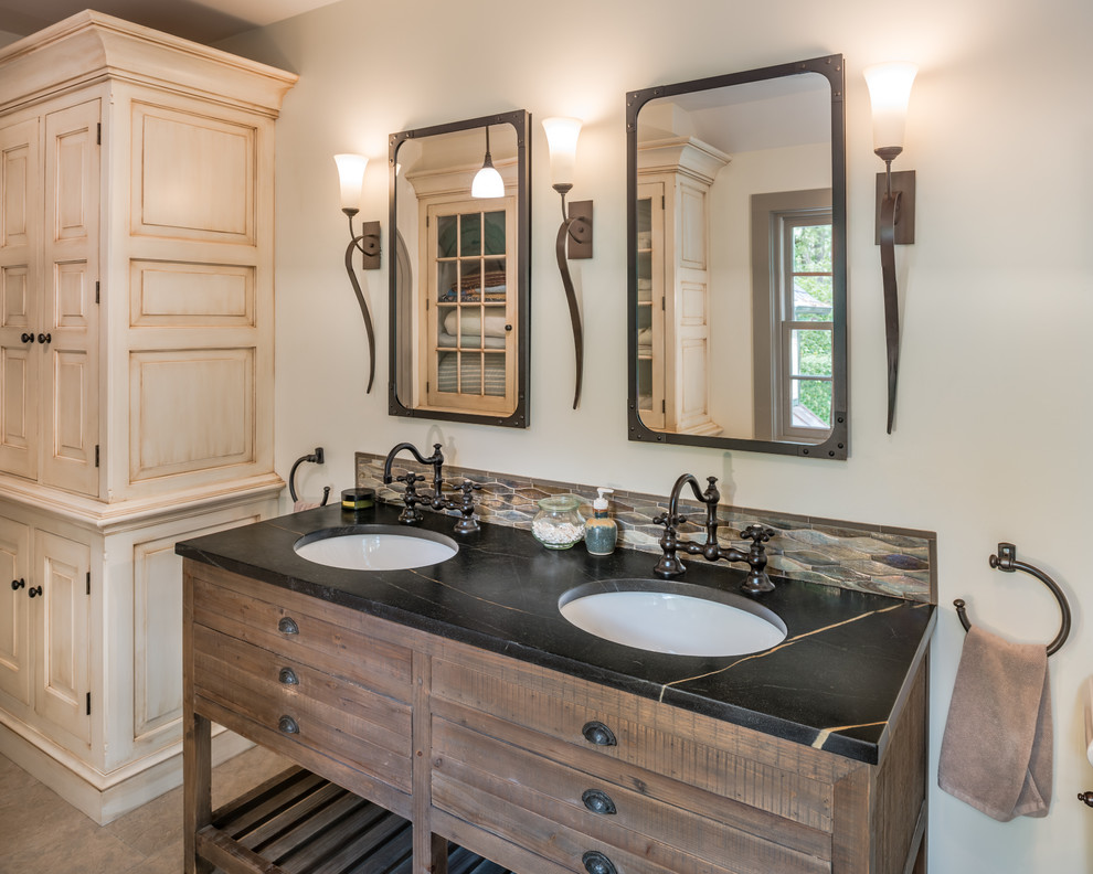 This is an example of a small country master bathroom in Philadelphia with grey walls, an undermount sink, soapstone benchtops, grey floor, dark wood cabinets, black benchtops and flat-panel cabinets.