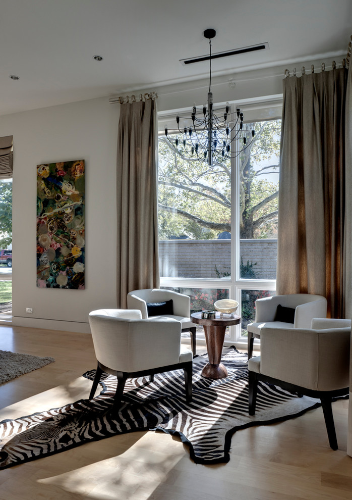 This is an example of a contemporary living room in Dallas with white walls and light hardwood floors.