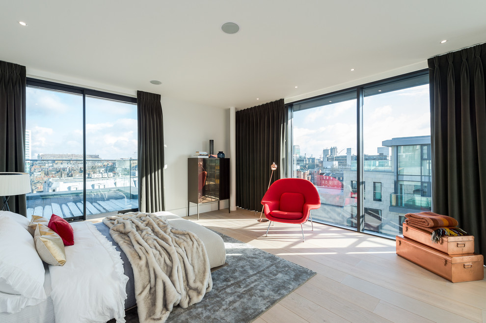 Photo of a mid-sized contemporary bedroom in London with white walls, light hardwood floors and beige floor.