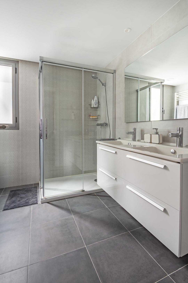 Photo of a large contemporary 3/4 bathroom in Other with flat-panel cabinets, white cabinets, a corner shower, gray tile, porcelain tile, porcelain floors, an integrated sink, grey floor, a hinged shower door and beige benchtops.