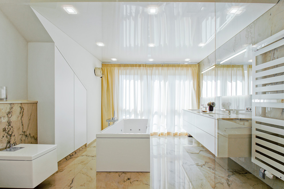 Mid-sized contemporary master bathroom in Other with flat-panel cabinets, white cabinets, a hot tub, a curbless shower, white walls, an undermount sink, granite benchtops, a wall-mount toilet, stone slab and beige floor.