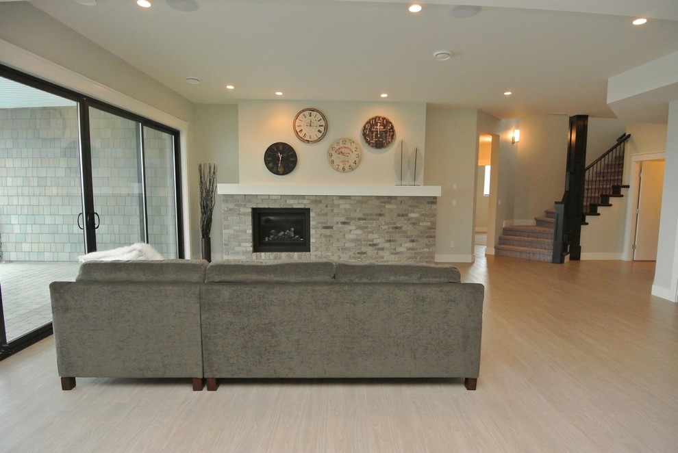 This is an example of a large transitional open concept family room in Other with grey walls, vinyl floors, a standard fireplace, a brick fireplace surround, no tv and beige floor.