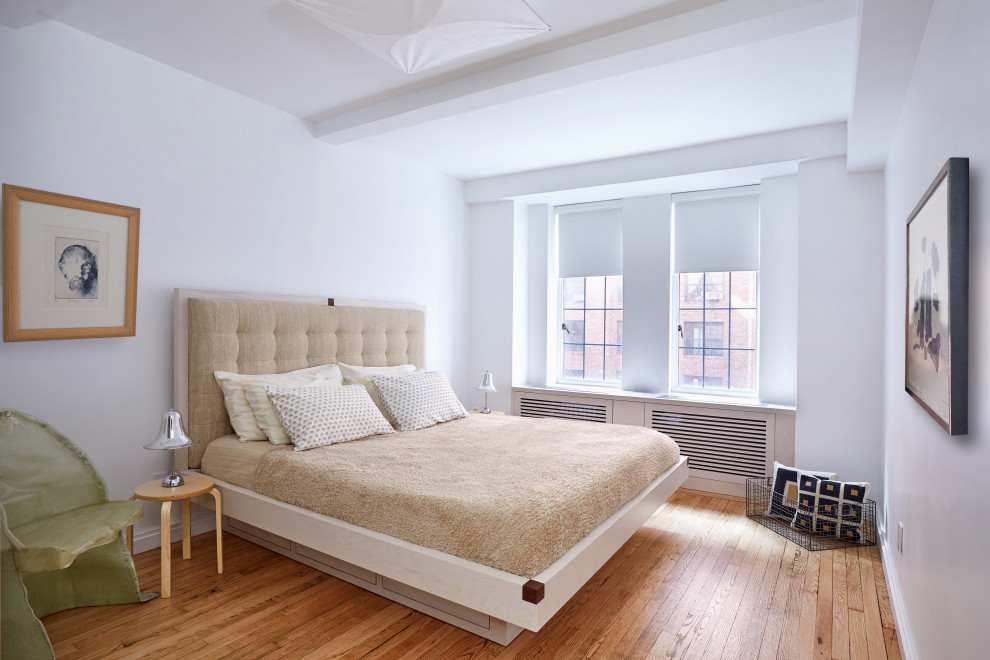 Foto de dormitorio principal actual pequeño con paredes blancas, suelo de madera clara y suelo beige