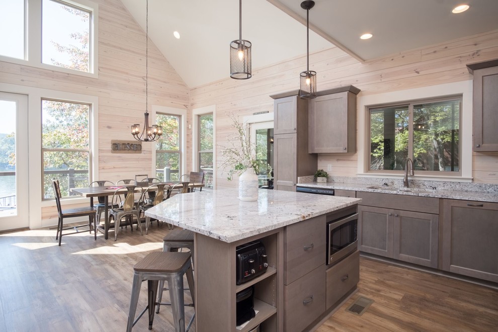 Country eat-in kitchen in Birmingham with an undermount sink, shaker cabinets, brown cabinets, dark hardwood floors, with island, brown floor and multi-coloured benchtop.