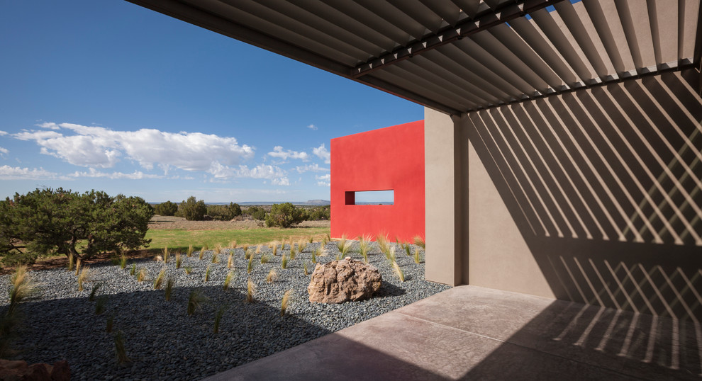 Inspiration for a large contemporary one-storey adobe grey exterior in Albuquerque with a flat roof.