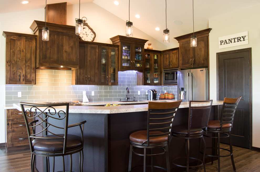 Inspiration for a rustic l-shaped brown floor eat-in kitchen remodel with shaker cabinets, brown cabinets, laminate countertops, gray backsplash, stainless steel appliances, an island and beige countertops