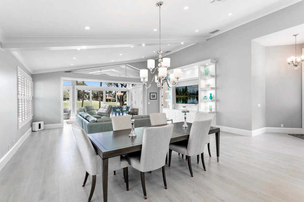 Expansive traditional open plan living room in Miami with grey walls, porcelain flooring, a built-in media unit, grey floors and a vaulted ceiling.